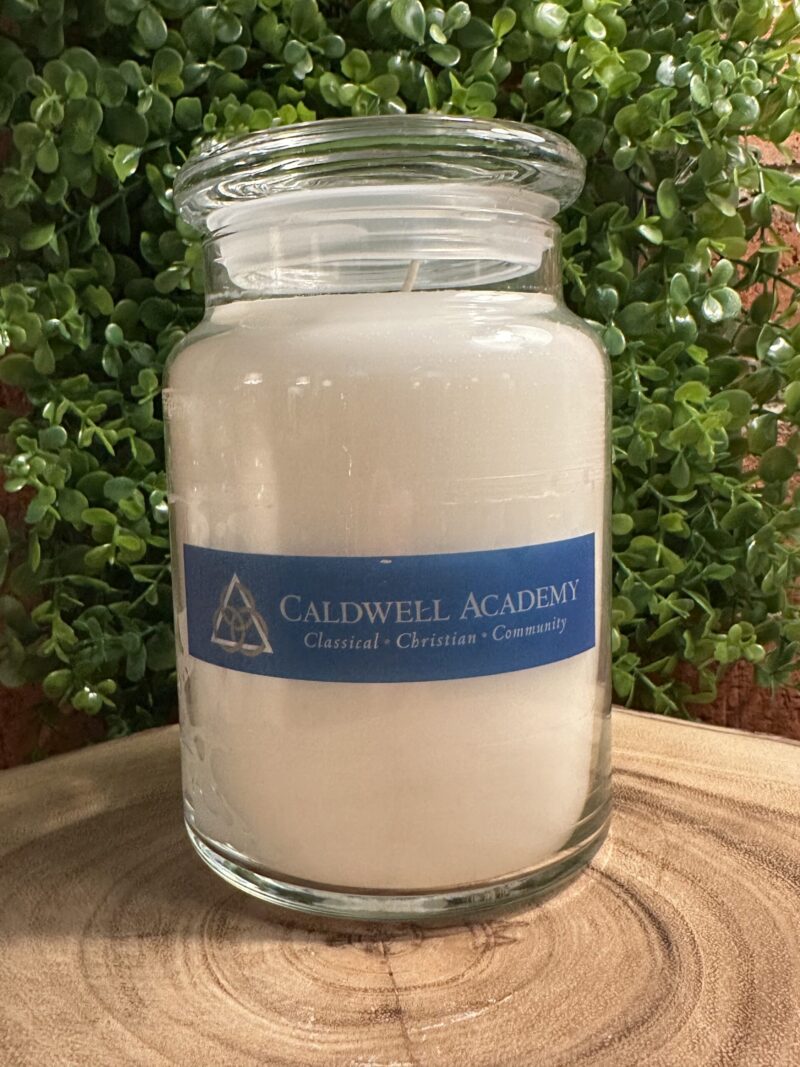 One of The Lighthouse Candle Factory's Custom Corporate Candle Gifts inside a clear glass jar with white wax featuring the Caldwell Academy logo.