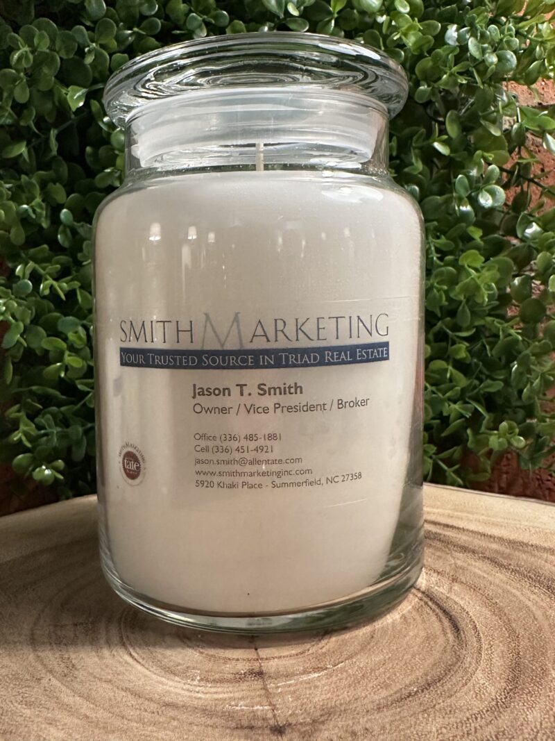 One of The Lighthouse Candle Factory's Custom Corporate Candle Gifts inside a clear glass jar with white wax featuring the Jason Smith logo.