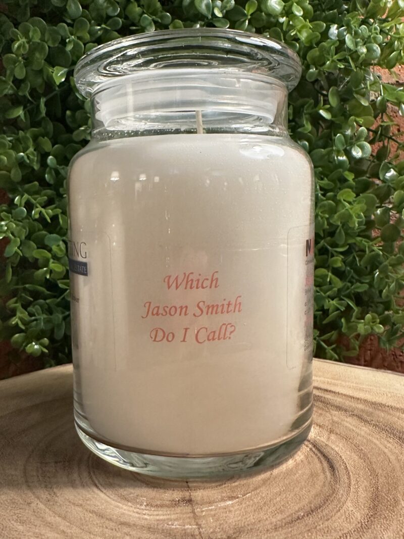 One of The Lighthouse Candle Factory's Custom Corporate Candle Gifts inside a clear glass jar with white wax featuring the Jason Smith logo.