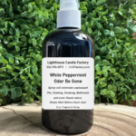 8 oz. White Peppermint Odor Be Gone (OBG) all-purpose fragrance spray by The Lighthouse Candle Factory in a dark bottle with a white fine mist sprayer.