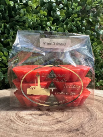 Black Cherry Wax Tarts with red wax and fluted edges in clear packaging with a gold logo