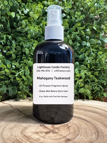 The Lighthouse Candle Factory's Mahogany Teakwood Fragrance Spray 8 oz. bottle with fine mist sprayer on wood background.