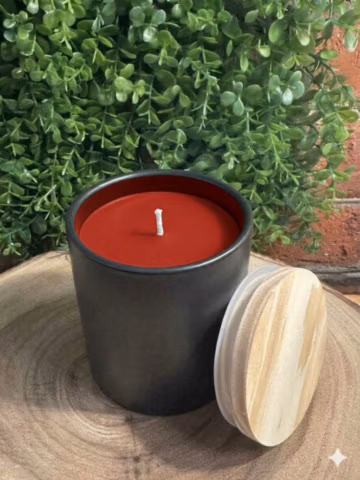 Apple Cinnamon Candle in a black ceramic vessel with crimson red wax — front view