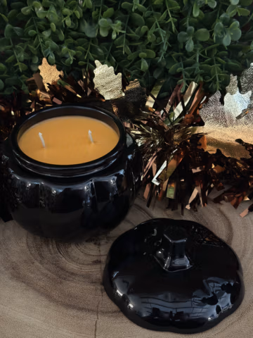 Unlit Pumpkin Pie Candle in an open black pumpkin jar with two wicks and a matching stemmed lid beside it.